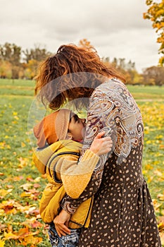 Happy Autumn Family. Cute Mother and Son Hugging in Fall Park
