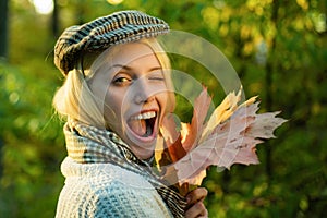 Happy autumn girl winking - close up portrait. Sweet young sensual sexy woman walking in autumn park. Autumn Clothing