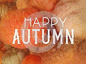 Happy Autumn in white typography letters on slightly blurred and textured orange pumpkins and gourds, fall festival or autumn harv