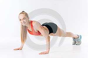 Happy awesome fit girl is loking at the camera while pressing up