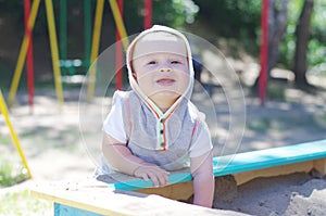 Happy baby age of 9 months plays in sandpit