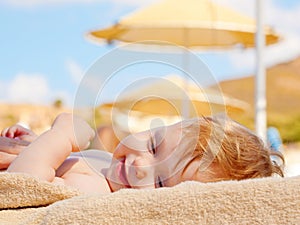 Happy baby on the beach sunbed.