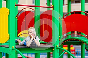 Happy baby boy 5-6 years old playing on the Playground in the yard in the summer. Children`s lifestyle