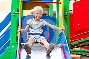 Happy baby boy 5-6 years old playing on the Playground in the yard in the summer. Children`s lifestyle