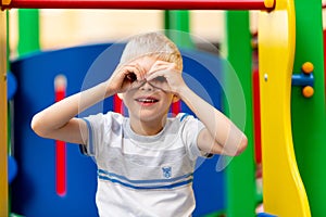 Happy baby boy 5-6 years old playing on the Playground in the yard in the summer. Children`s lifestyle