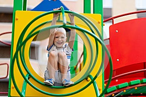 Happy baby boy 5-6 years old playing on the Playground in the yard in the summer. Children`s lifestyle