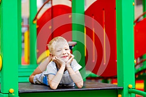 Happy baby boy 5-6 years old playing on the Playground in the yard in the summer. Children`s lifestyle