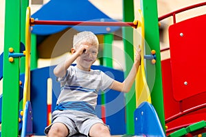 Happy baby boy 5-6 years old playing on the Playground in the yard in the summer. Children`s lifestyle