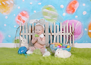 Happy baby boy with easter headband in easter scene