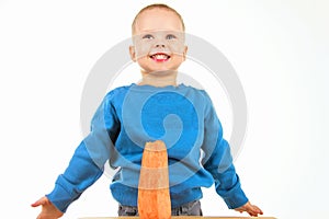 Happy baby boy eating carrot, on white background