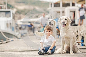 Happy baby boy with him dog on berth in summer