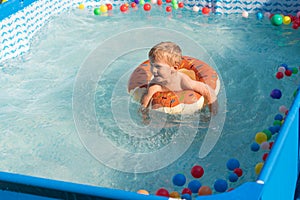 Happy baby boy playing with colorful inflatable ring