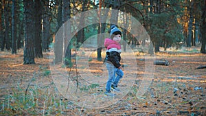 Happy baby boy running in autumnal park. Little child playing on autumn walk. Autumnal forest with golden leaves.