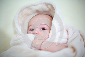 Happy baby boy wrapped towel after bath