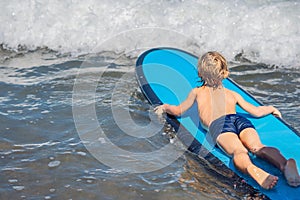 Happy baby boy - young surfer ride on surfboard with fun on sea