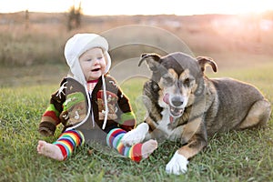 Happy Baby Bundled up Outside in Winter with Pet Dog