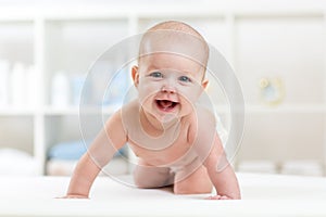 Happy baby child crawling on bed and smiling