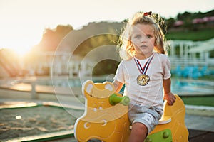 Happy baby child riding a yellow cow at the playground