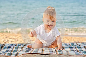 Happy baby crawling on the beach.