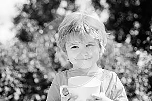 Happy baby with a cup of milk or tea. Baby drink.