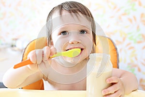 Happy baby eating fruity puree