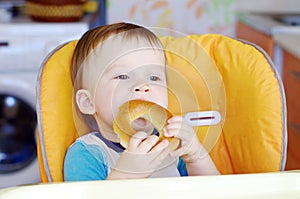 Happy baby eating round cracknel photo