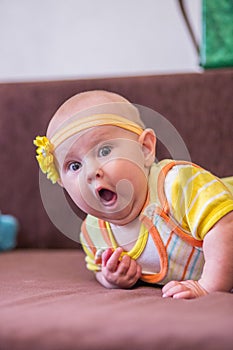 Happy baby girl on the bed. Cute little girl lies on the bed smiling. 6 months