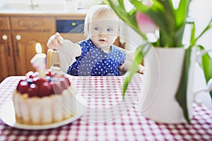 Happy baby girl in blue dress celebrating her first birthday