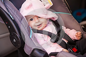 Happy baby girl in a car seat