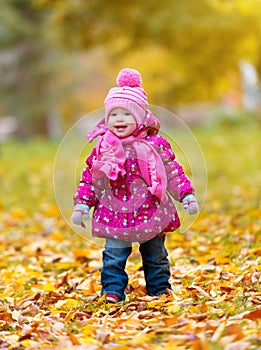 Happy baby girl child outdoors in the park in autumn