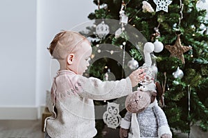 happy baby girl decorating the Christmas tree