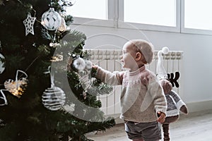happy baby girl decorating the Christmas tree