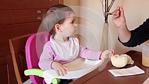 Happy baby girl eating with a spoon food