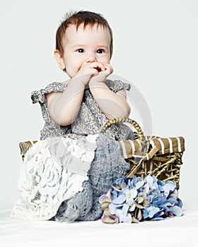 Happy baby girl with flowers. Cute child