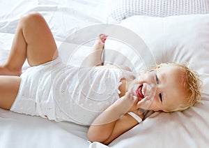 Happy baby girl laughing in bed