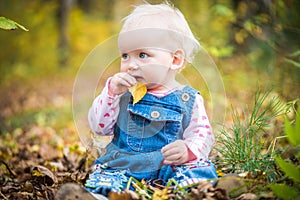 Happy baby girl laughing and playing in the autumn on the forest