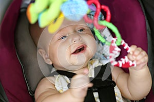 Happy Baby Girl Playing in Car Safety Seat