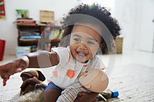 Happy Baby Girl Playing With Doll In Playroom