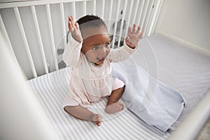 Happy Baby Girl Playing In Nursery Cot