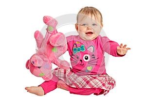 Happy baby girl plays with pink teddy bear