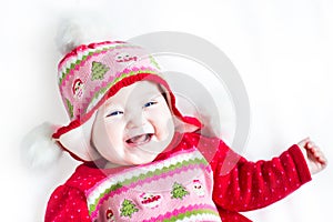 Happy baby girl in red dress with Christmas ornament