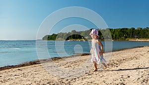 happy baby girl running on summer beach