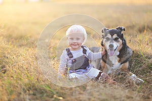 Happy Baby Girl Sitting in Field With Adopted German Shepherd Pe