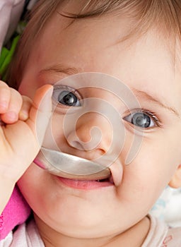 Happy baby girl with spoon
