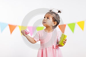 Happy baby girl with toy blocks at birthday party