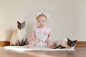 Happy baby girl with  two cats