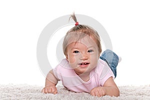 Happy baby girl on the white carpet