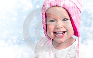 Happy baby girl in winter hat smiling on outdoors