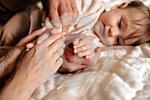 Happy baby and hands in focus as details of family happiness