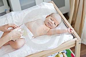 Happy baby having diaper changed photo